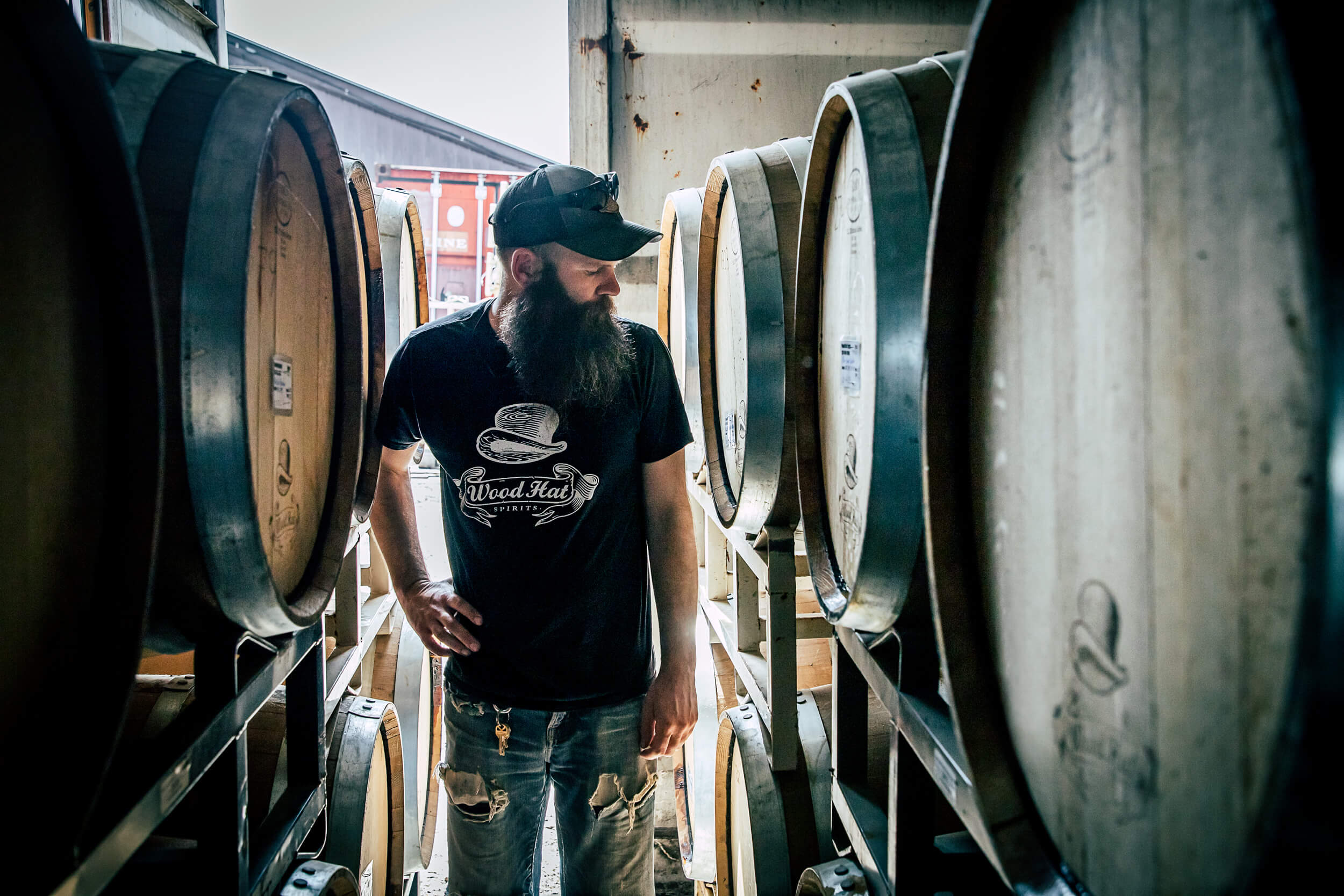 person checking over whiskey barrels