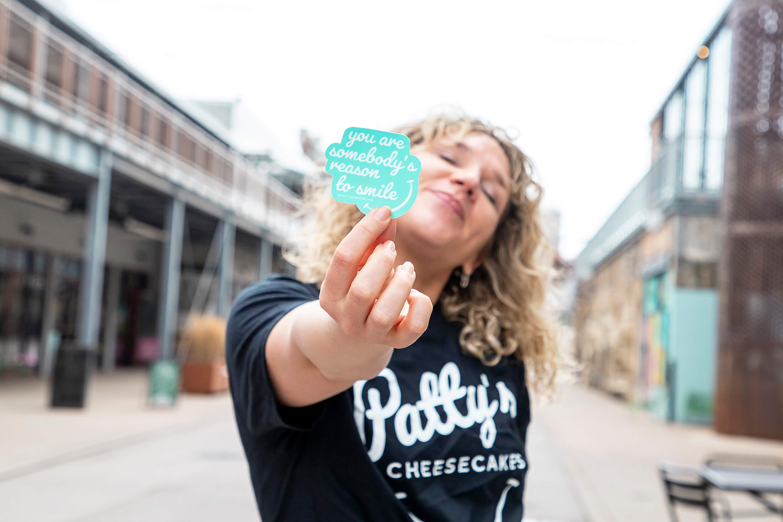 woman holding sticker and smiling
