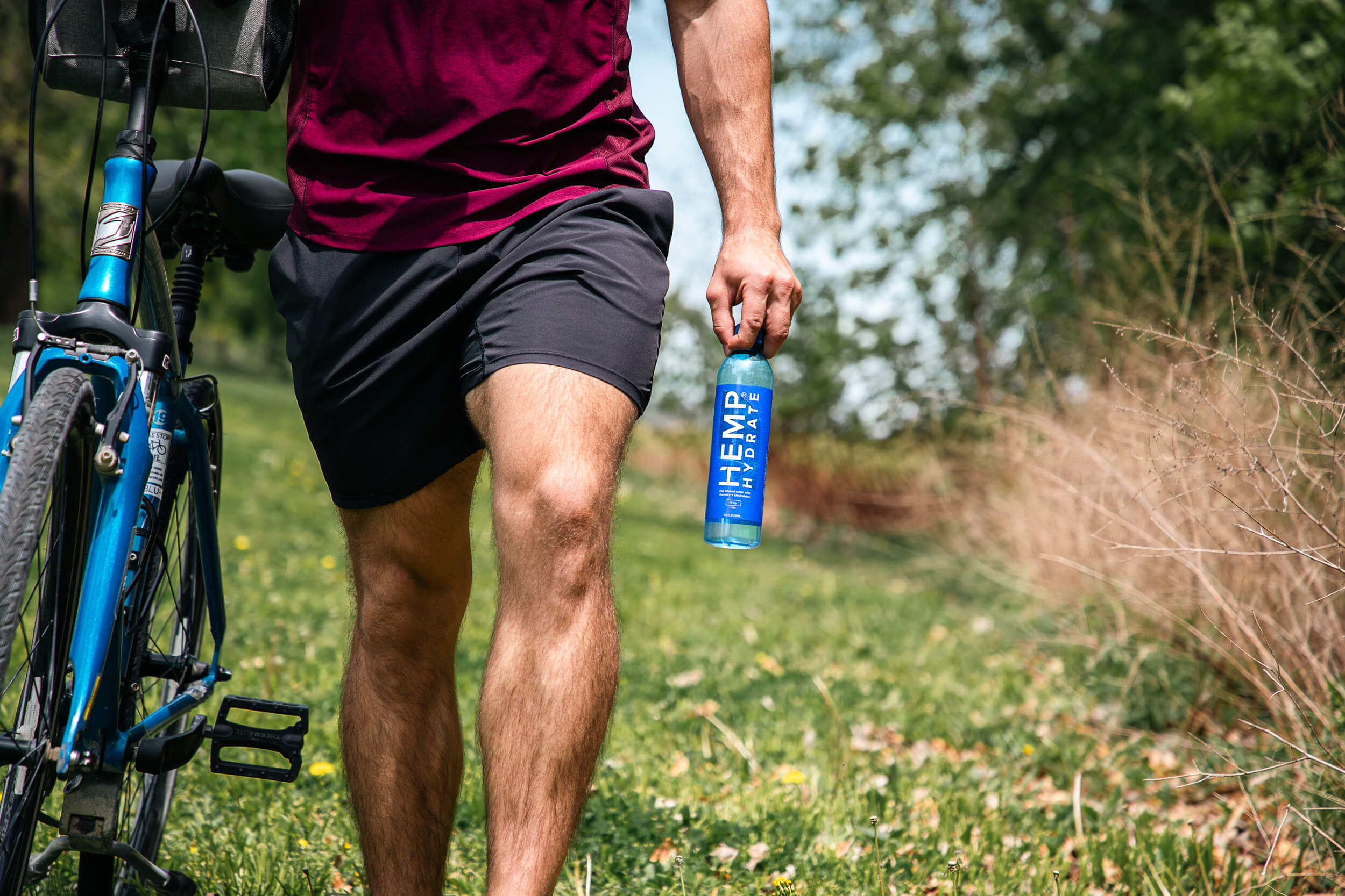 man walking next to mountain bike holding a bottle of water