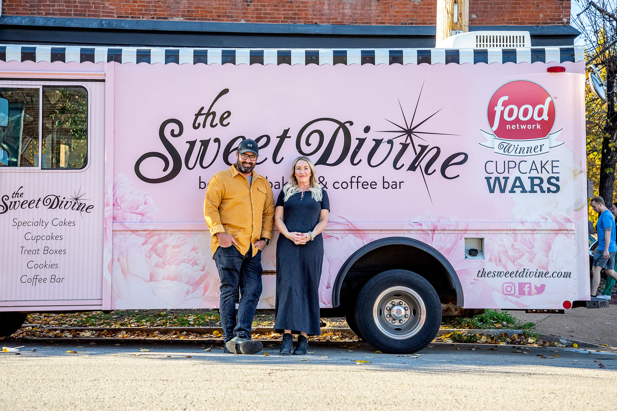portrait of couple standing with their food truck