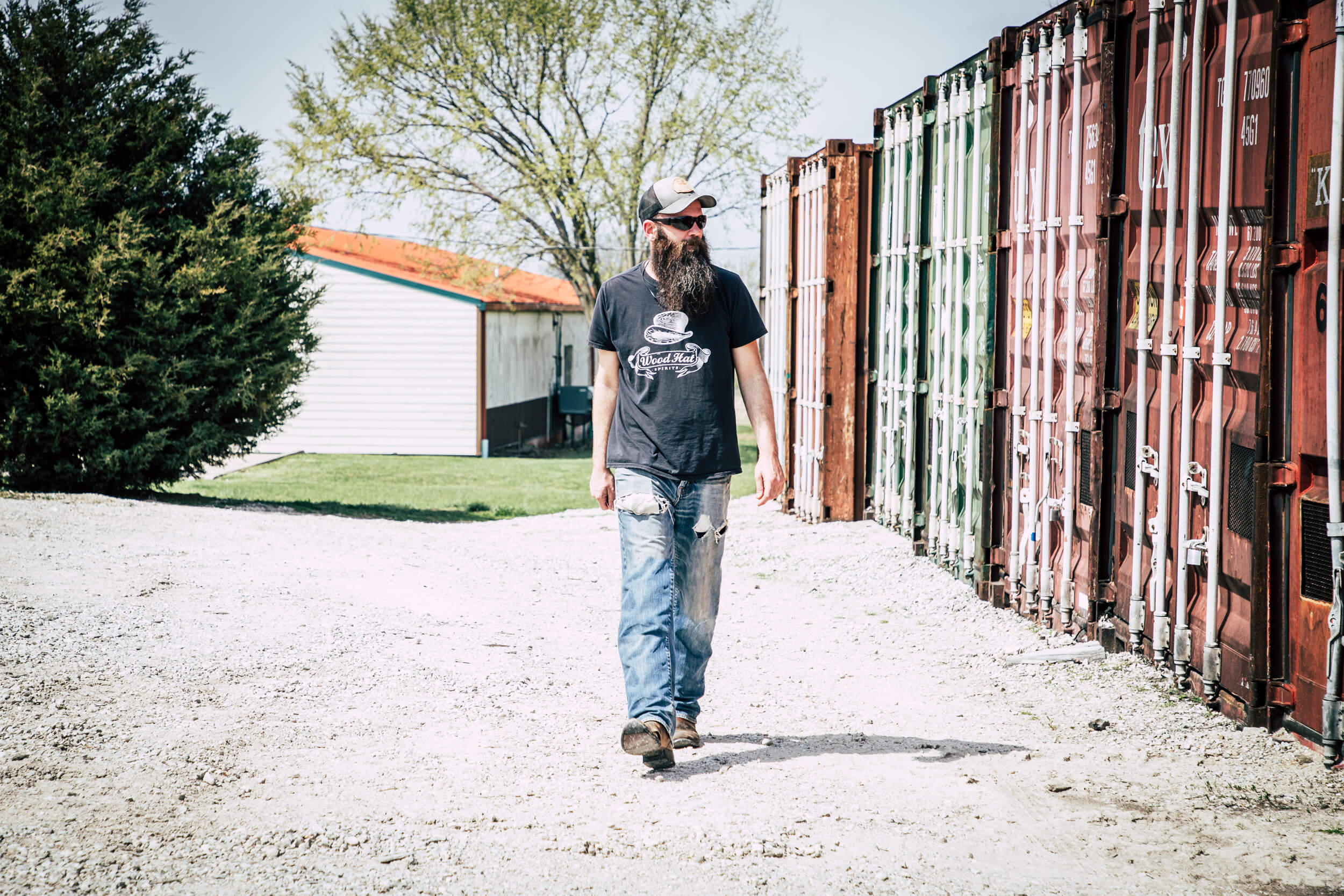 man walking by shipping containers