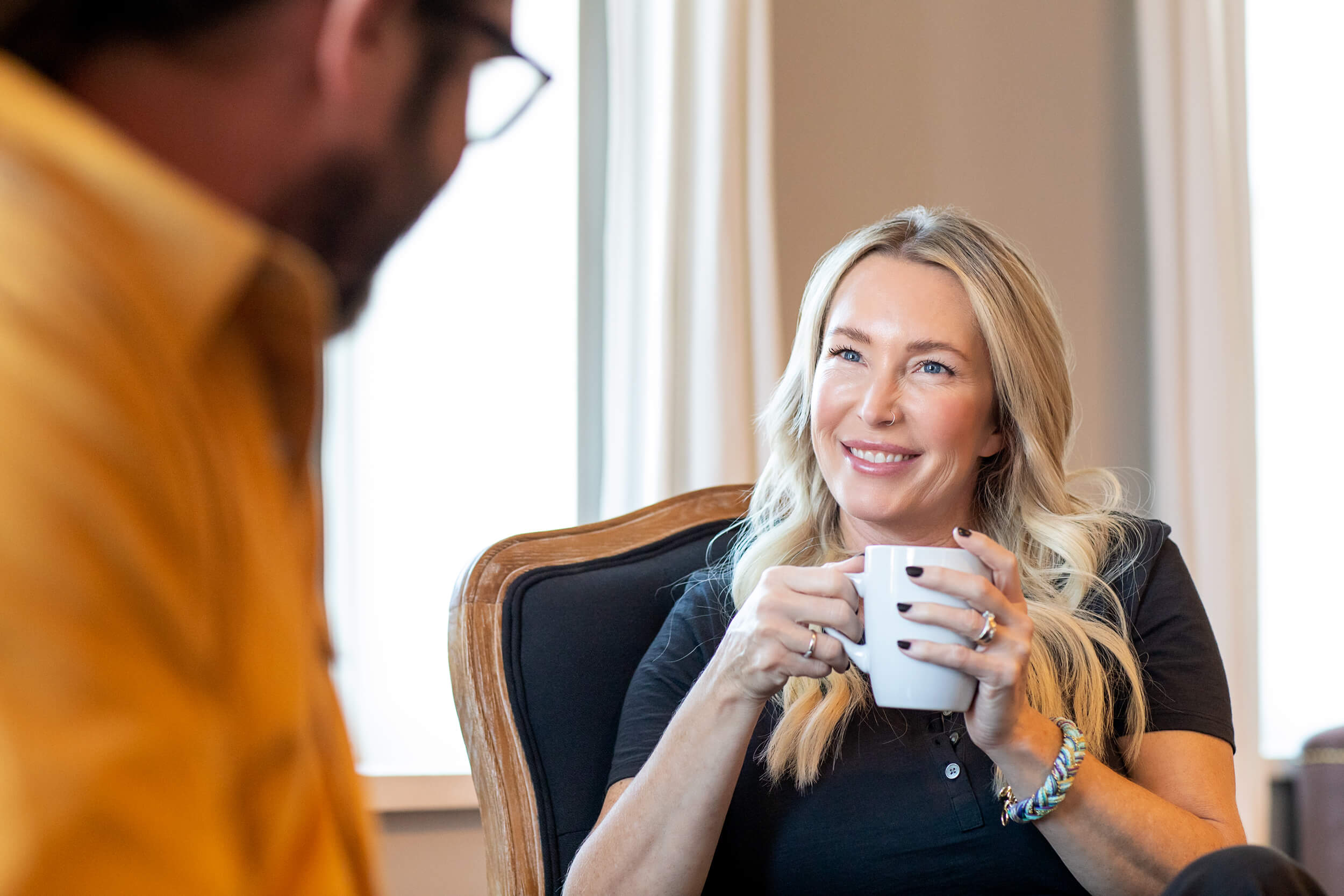 woman smiling holding coffee cup