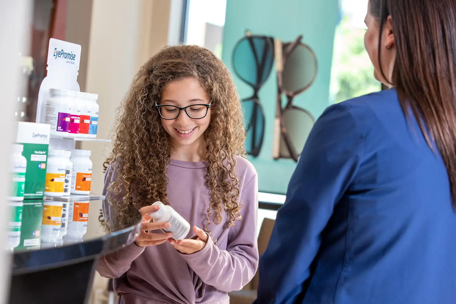St. Louis lifestyle photography for eye care company. teenager looking at bottle of eye care medication
