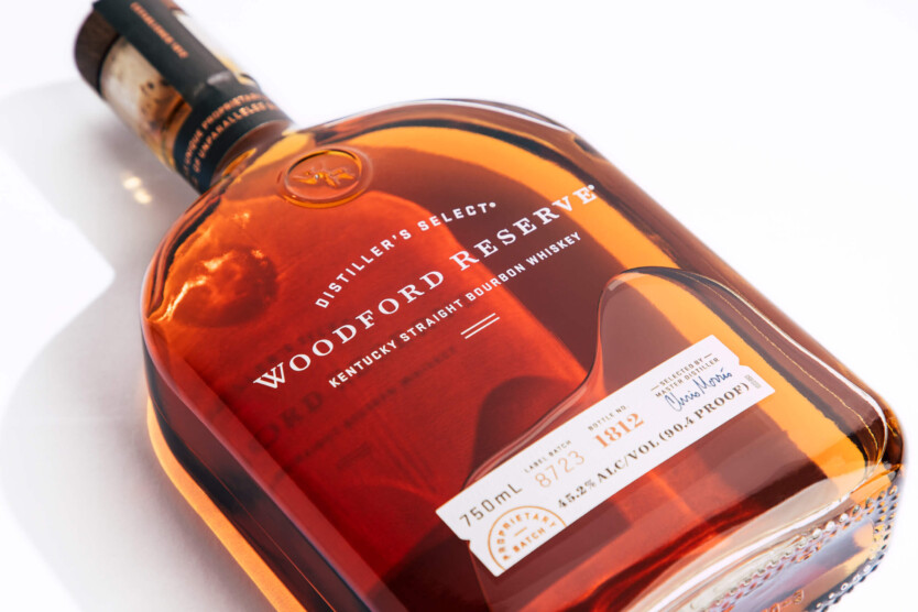 Bottle of Woodford reserve whiskey laying on a white surface.
